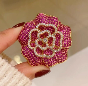 Vue détaillée de la broche camélia rose fuchsia au style rétro français et cristaux
