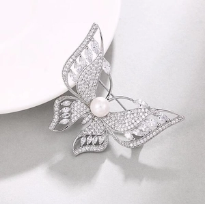 Broche papillon luxueuse ornée de cristaux scintillants et d'une perle blanche