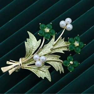 Spilla bouquet floreale dorata con pietre di opale verde e perle bianche su velluto