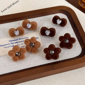Brown flocked flower and bow stud earrings with sparkling crystals in a display tray