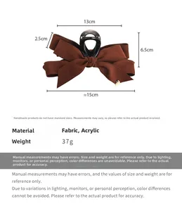 Detail view of large brown velvet bow hair claw clip with golden heart pendant