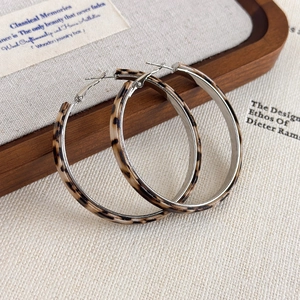 Detail of leopard print hoop earrings with silver metal inner lining and retro design
