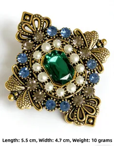 Dettaglio macro di spilla barocca vintage con cristallo smeraldo e perle finte bianche