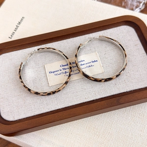Detailed view of large leopard print hoop earrings with silver metal inner lining