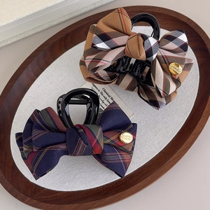 Classic British plaid bow hair clips featuring fabric textures and gold logo charm detail