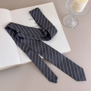 Close-up of dark grey striped necktie with elegant white diagonal patterns on a book