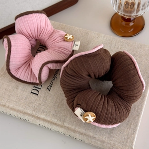 Eleganti elastici per capelli rosa e marroni con stella marina su libri vintage