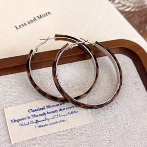 Close-up of leopard print hoop earrings with silver metal inner lining and buckle detail