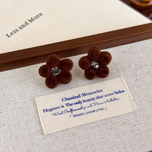 Detail view of brown flocked flower earrings with a sparkling rhinestone center for women