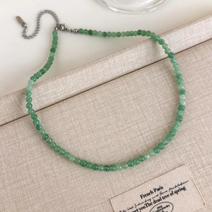 Gros plan du collier de perles vertes avec texture pierre naturelle et fermoir argenté
