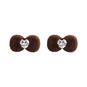 Detailed macro view of flocking velvet bow earrings with heart-shaped crystal centers