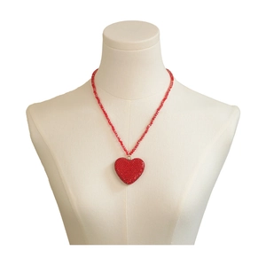 Collier avec pendentif cœur en cristal rouge étincelant présenté sur un mannequin blanc