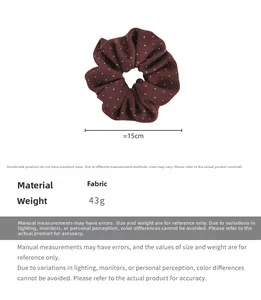 Detail view of a burgundy polka dot fabric scrunchie with 15cm diameter size specifications