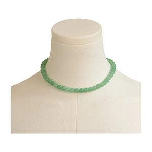 Élégant collier de perles en pierre naturelle vert clair sur un buste d'exposition