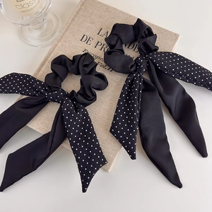Elegant polka dot bow scrunchie set with long ribbons on a vintage book backdrop
