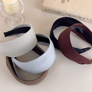 Detail of assorted solid color wide fabric headbands in grey blue and brown tones