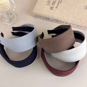Close-up of wide fabric headbands in five colors with textured twill and non-slip lining