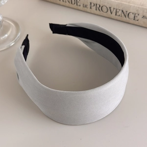 Detail of light gray fabric headband showing twill texture and black non-slip inner lining