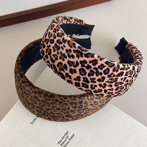 Two-pack leopard print padded velvet headbands with vintage high crown design on white books