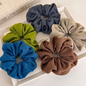 Lot de 5 chouchous en tricot doux aux tons automnaux sur un plateau blanc élégant