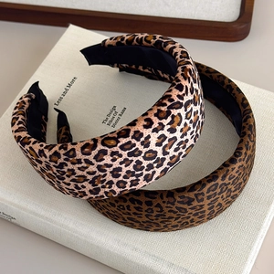Leopard print velvet headbands in light and dark brown on a white book display