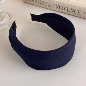 Detailed view of navy blue wide headband featuring premium twill texture and fabric finish