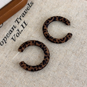 Dettaglio degli orecchini vintage a forma di C con stampa leopardata e floccata