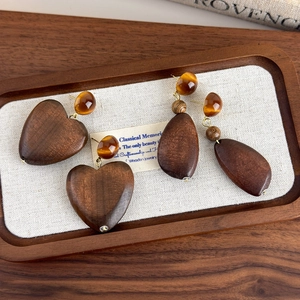 Retro geometric wooden earrings set with amber resin beads on a display tray