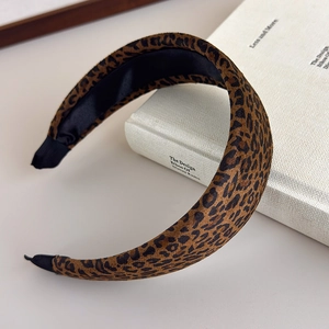 Detail of leopard print velvet headband with black lining on a white decorative book