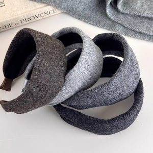 Close-up of thick knitted headbands in grey and brown tones with cozy wool texture