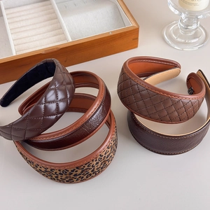 Détails rapprochés de serre-têtes en cuir PU marron avec motifs à carreaux vintage
