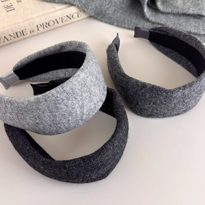 Close-up of three knitted headbands in grey shades with soft texture and anti-slip lining