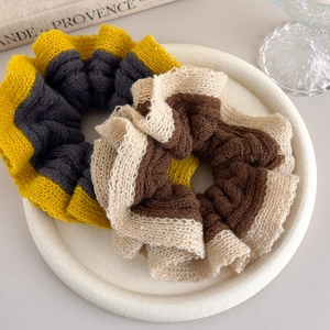 Detail of oversized knit scrunchies with subtle sequins and elegant color blocking