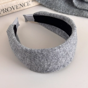 Detail of gray knitted headband showing soft textured fabric and black non-slip inner lining
