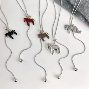 Detail of horse pendant necklaces with adjustable snake chains and various lacquer finishes