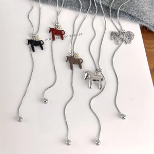 Detail of five horse-shaped pendants on snake chains with elegant star accents