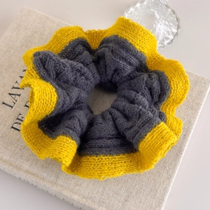 Detail of grey and yellow contrast knit scrunchie with crochet wavy lace edge texture