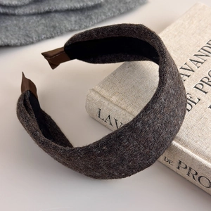 Close-up of thick coffee brown knit headband with soft texture on a vintage book