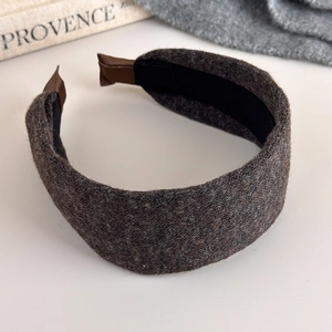 Detail of grey knitted wide headband with brown leather ends and black non-slip lining