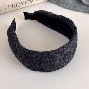 Detailed close-up of dark grey thick knitted headband with smooth black satin lining