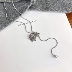 Detail view of silver snake chain necklace featuring a textured double swan pendant design