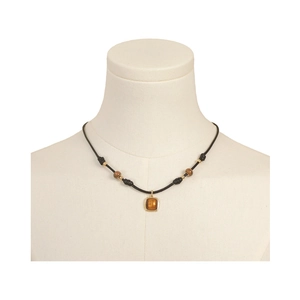 Detailed close-up of tiger eye pendant on a black cord necklace with golden beads