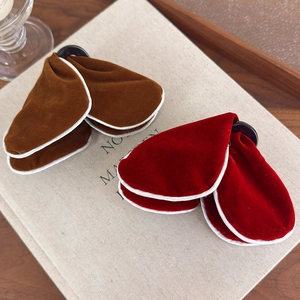 Detail of velvet butterfly hair claws with elegant white piping in red and brown colors