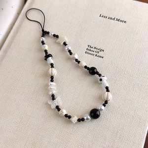 Detail of beaded phone strap with mushroom and star charms on an aesthetic book