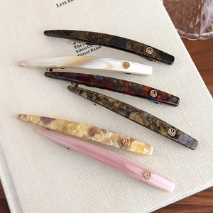 Set of six minimalist acetate hair clips with gold metal logo in various elegant colors