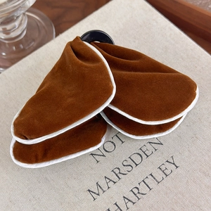 Detailed close-up of caramel velvet bow hair clip with white piping and black metal ring