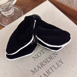 Detail of elegant black velvet butterfly hair claw clip with white contrast trim
