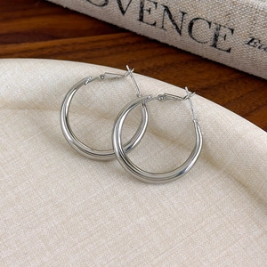 Boucles d'oreilles créoles argentées minimalistes avec finition polie sur fond vintage