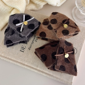 Detailed view of plush polka dot hair claws with handmade gold tags and ribbon bows