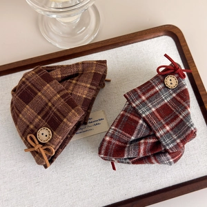 Detail of British style plaid beret hats featuring wooden buttons and bow decorations